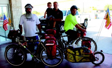 Bob Quick, left, and his son Conrad, right, are making a cross-country bike trip and stopped in La Grange Tuesday. La Grange residents Derryl Dennis and his son Cash, center, hosted them for the night before the Quicks kept pedaling eastward Wednesday.