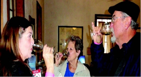 It’s bottoms up for Glenda Herzog, Gladys Musgrove and Larry Herzog at Saturday’s La Grange Uncorked wine and food festival.